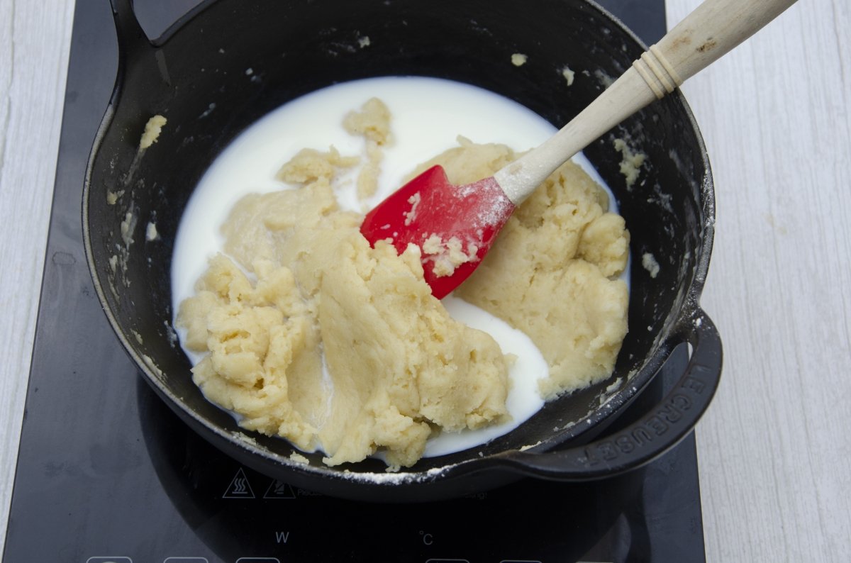 Añadiendo la leche a las croquetas de cocido