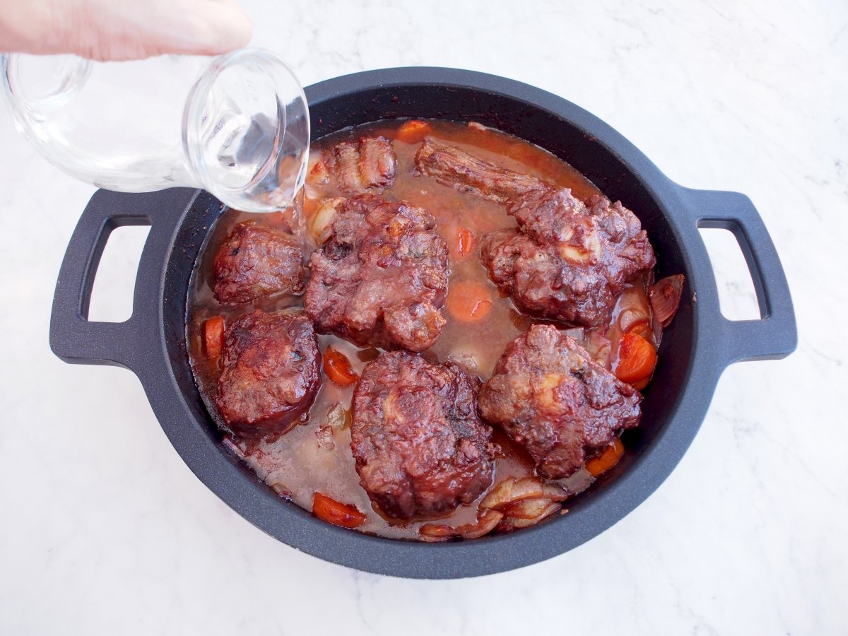 Añadir el agua para cocinar el rabo de toro