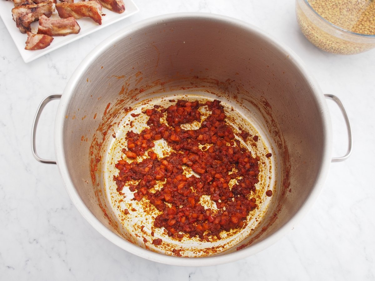 Añadir el tomate al sofrito de las lentejas con costillas