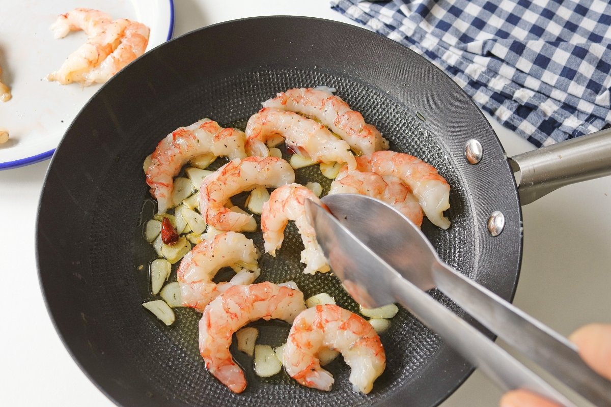 Añadir las gambas para cocinarlas al ajillo