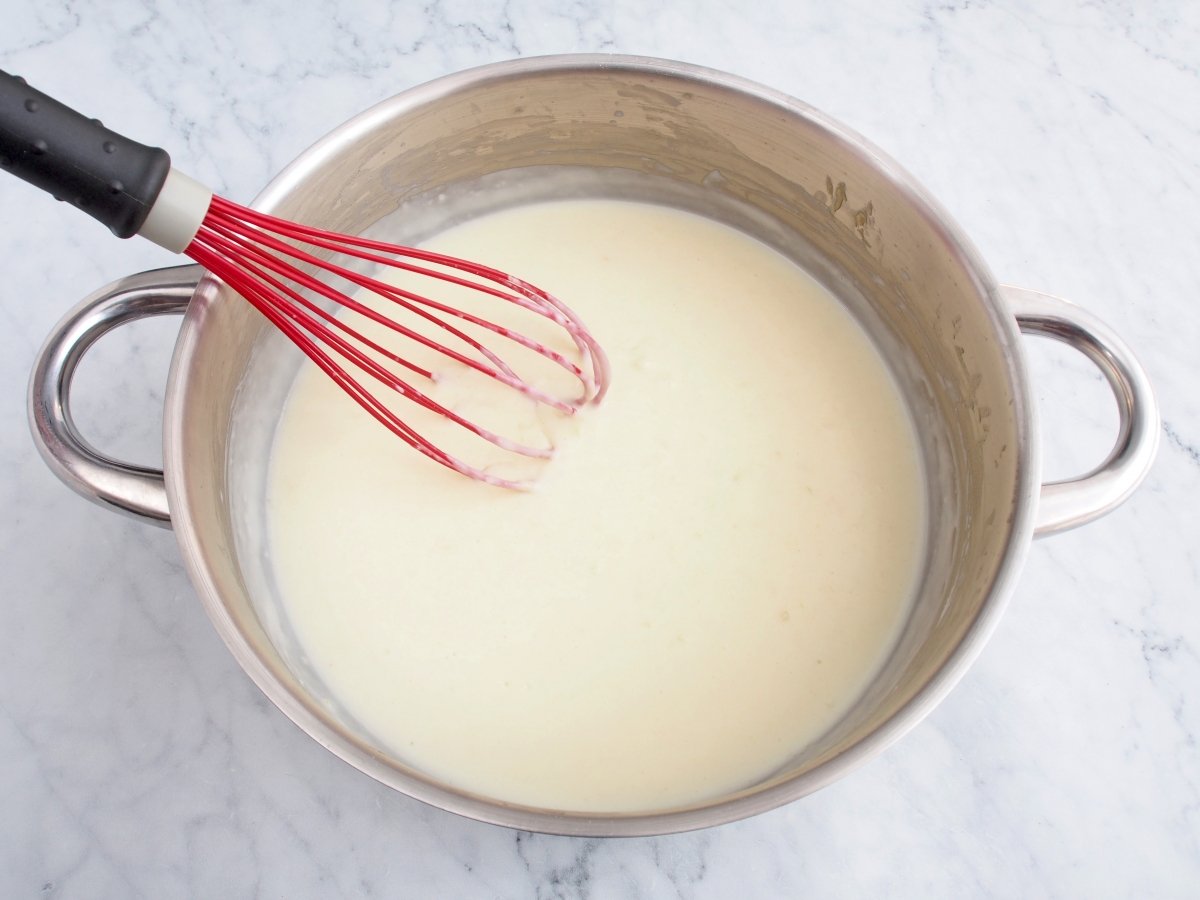 Añadir la leche a la bechamel de las croquetas de bacalao
