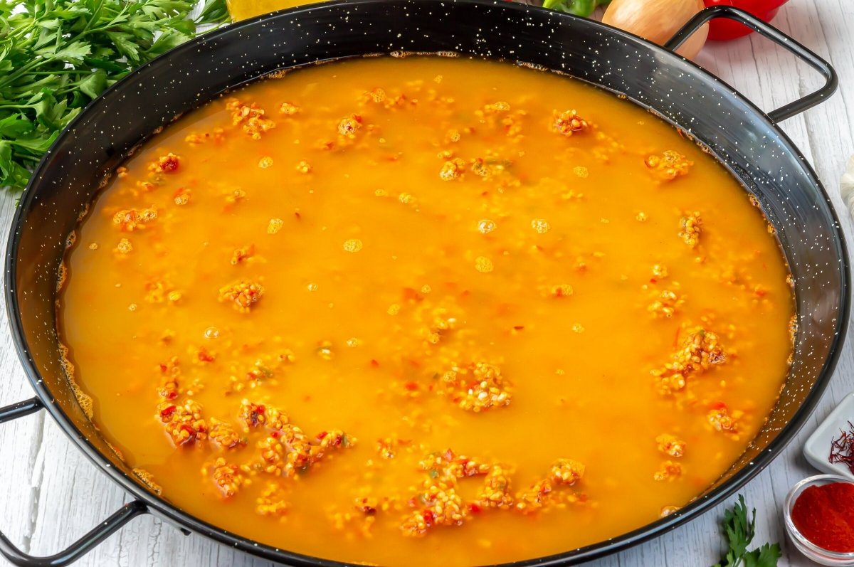 Cubrir el arroz con el caldo de marisco