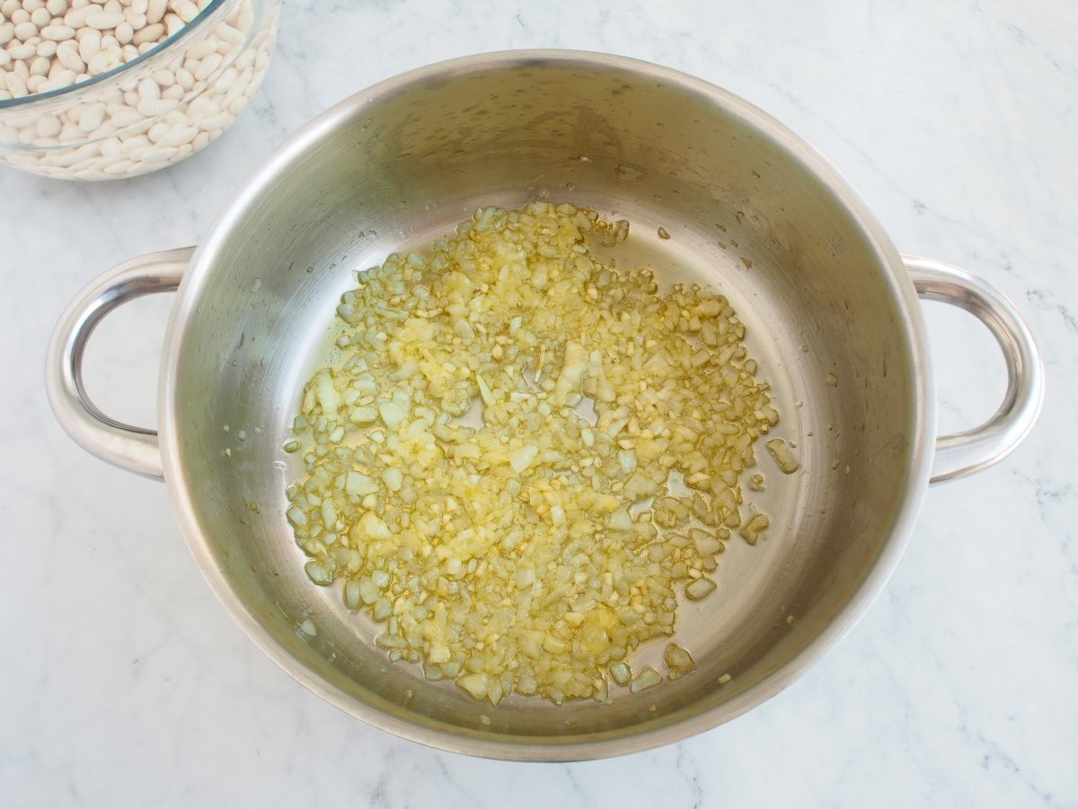 Hacer un sofrito de cebolla para las alubias blancas con verduras