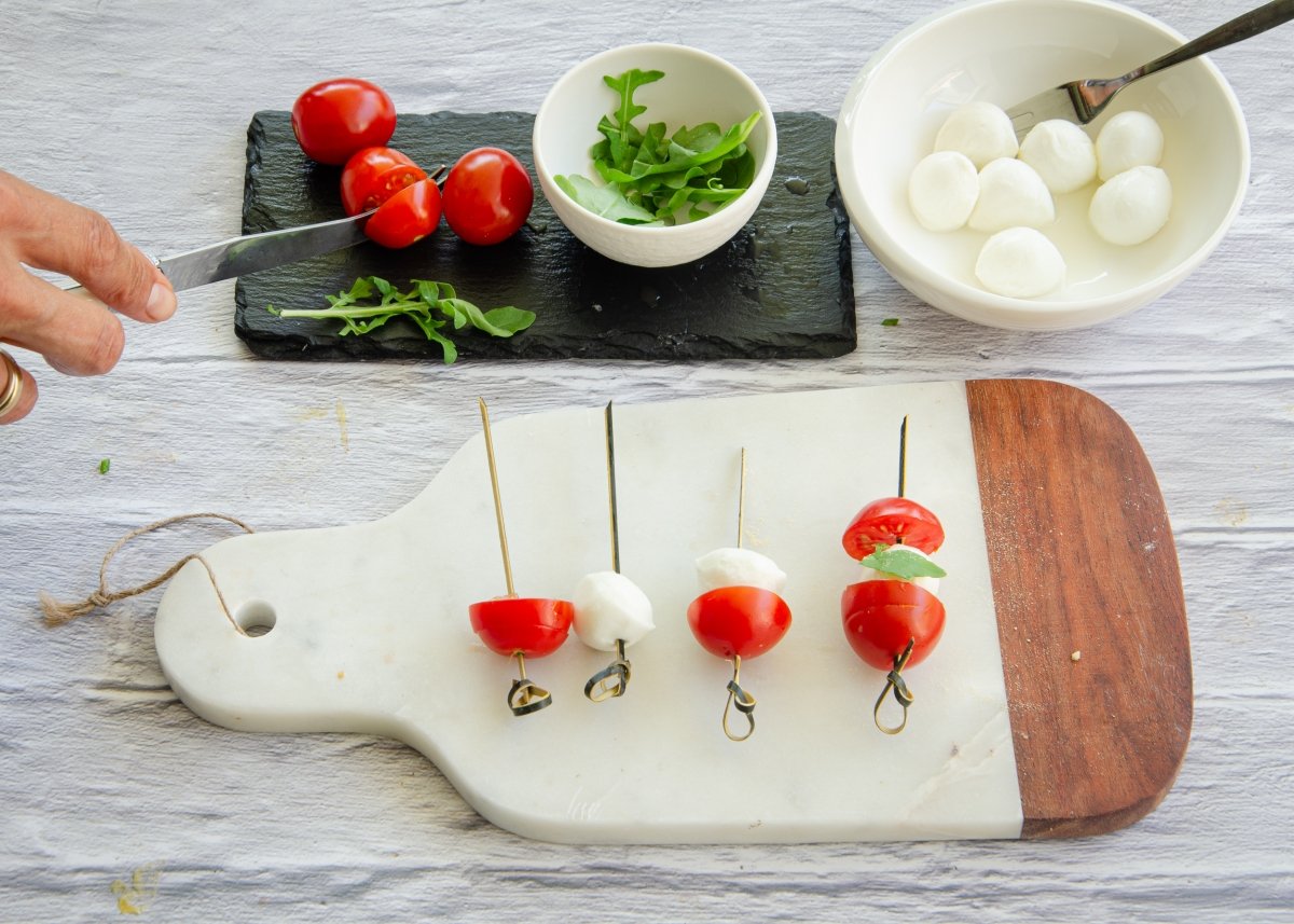 Preparando canapés de tomate y mozarella