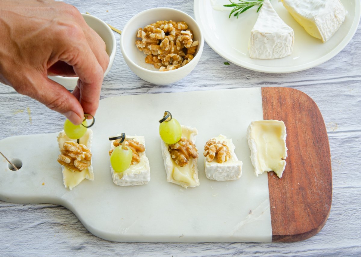 Preparando los canapés de queso brie y uvas