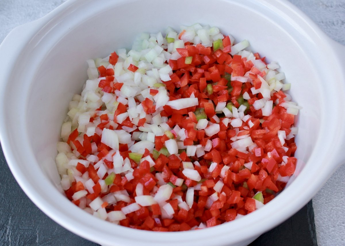 Recipiente con la cebolleta y los pimientos troceados