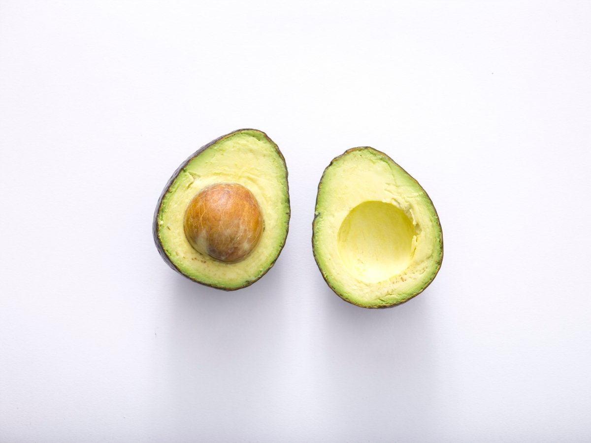 Un aguacate abierto por la mitad con su hueso a al vista